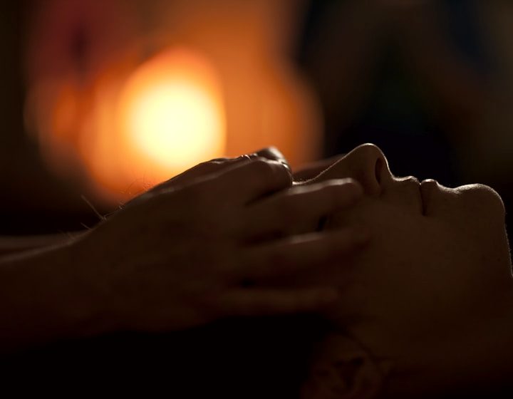 Face and head massage in dim, warm light